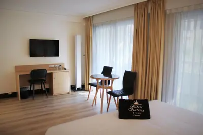 a hotel room with a bed and a table and chairs at Hôtel Victoria in Cannes