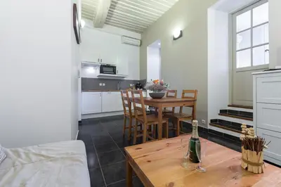 a kitchen and dining room with a table with a bottle of wine at Florella Maréchal Joffre in Cannes