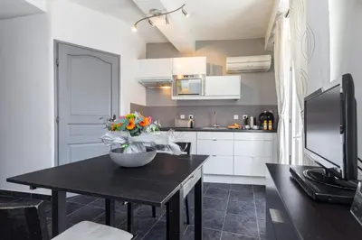 a kitchen with a table with a bowl of flowers on it at Florella Maréchal Joffre in Cannes