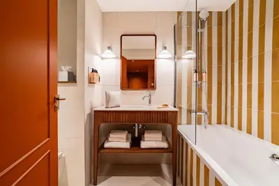 a bathroom with a sink and a tub and a mirror at Hôtel Lepoussin in Cannes