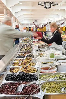 a group of people standing in a grocery store selling fruit at Suquet26 in Cannes