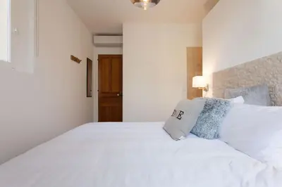 a white bedroom with a large white bed with pillows at Budin Sea Cannes in Cannes