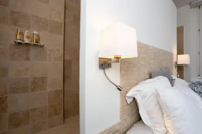 a bedroom with a bed with a lamp on the wall at Budin Sea Cannes in Cannes