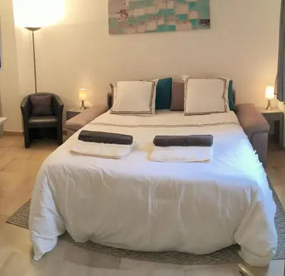 a large white bed in a room with a couch at Suquet's Luxury Studio in Cannes