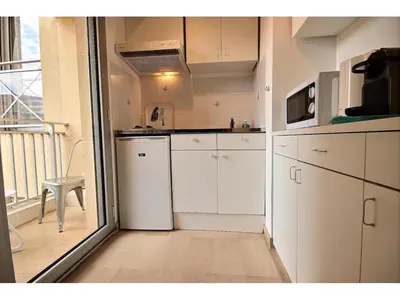 a small kitchen with white appliances and a balcony at Suquet's Luxury Studio in Cannes