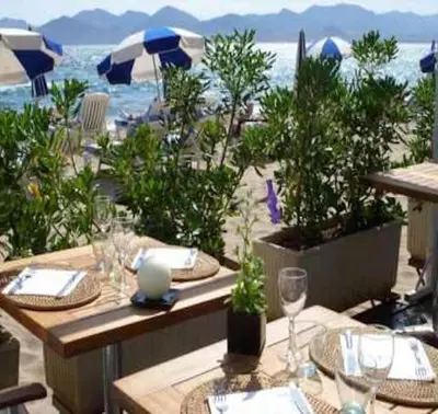 a table with plates and glasses on top of a beach at Suquet's Luxury Studio in Cannes