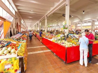 a group of people standing in a market with fruits and vegetables at Suquet's Luxury Studio in Cannes