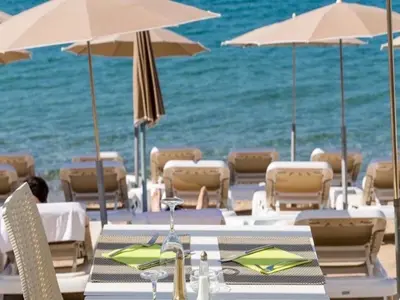 a table with chairs and umbrellas on a beach at Suquet's Luxury Studio in Cannes