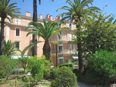 a building with palm trees in front of it at Le Pavillon113 in Cannes