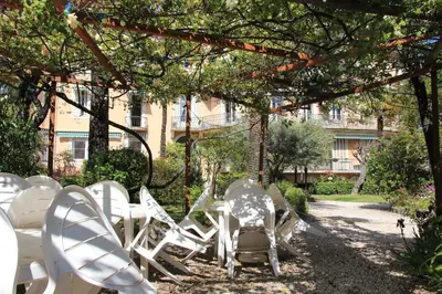 a group of white chairs sitting under a tree at Le Pavillon113 in Cannes