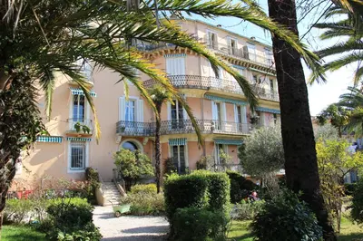 a building with palm trees in front of it at Le Pavillon113 in Cannes