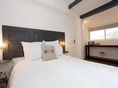 a bedroom with a large white bed with a black headboard at Suquet Sea Cannes in Cannes