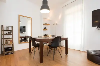 a dining room table with black chairs and a mirror at Suquet Sea Cannes in Cannes