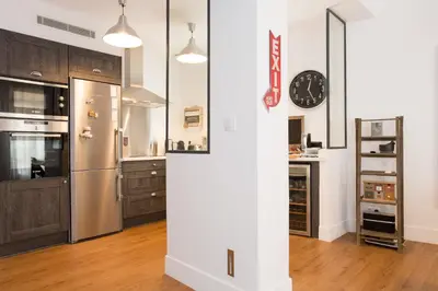 a kitchen with a refrigerator and a clock on the wall at Suquet Sea Cannes in Cannes