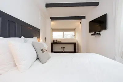 a white bed with white pillows and a flat screen tv at Suquet Sea Cannes in Cannes