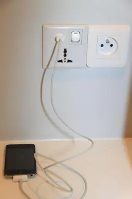 a cell phone plugged into an outlet on a wall at From Hollywood to Bollywood 2 Bedrooms 2 Bathrooms - 1 min from Croisette&Beach, 12 Min from the Palais in Cannes