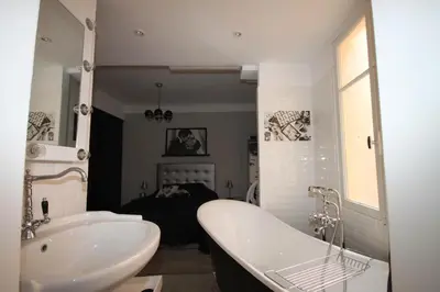 a bathroom with a tub and a sink and a bath tub at From Hollywood to Bollywood 2 Bedrooms 2 Bathrooms - 1 min from Croisette&Beach, 12 Min from the Palais in Cannes