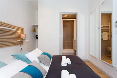 a bedroom with a bed with white and blue at Teisseire Accomodations in Cannes