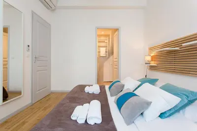 a bedroom with a bed with white and blue pillows at Teisseire Accomodations in Cannes