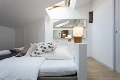 a bedroom with a white bed and a window at Teisseire Accomodations in Cannes