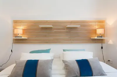 a bedroom with two beds and two lamps on the wall at Teisseire Accomodations in Cannes