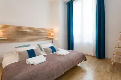 a bedroom with a large bed with two towels on it at Teisseire Accomodations in Cannes