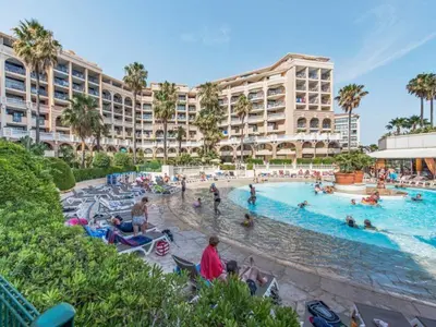 a large swimming pool with people in a resort at #Cannes Boccacabana Beach, Seafront, in Résid Pierre&Vacances Classé 3 Stars in Cannes