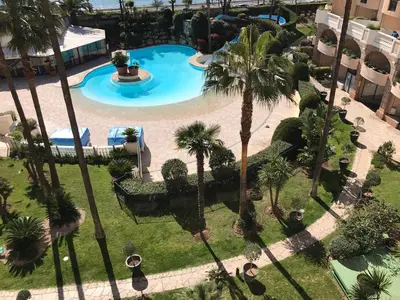 an overhead view of a swimming pool with palm trees at Appartement Vue Mer Cannes Azur in Cannes