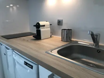 a kitchen counter top with a sink and aounter at Appartement Vue Mer Cannes Azur in Cannes