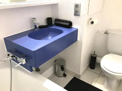 a blue sink in a bathroom with a toilet at Appartement Vue Mer Cannes Azur in Cannes