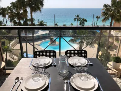 a table with wine glasses and a view of the ocean at Appartement Vue Mer Cannes Azur in Cannes