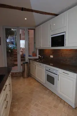 a small kitchen with red cabinets and a counter at Cannes, Le Suquet in Cannes