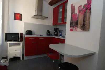 a white kitchen with a table and a white counter at Cannes, Le Suquet in Cannes