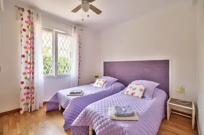 a bedroom with two beds with purple comforters at Cannes Film Festival Beach Apartment in Cannes