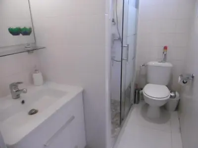 a white bathroom with a toilet and a sink at Cannes Film Festival Beach Apartment in Cannes