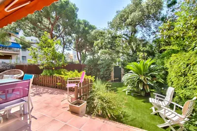a patio with chairs and a garden with trees at Cannes Film Festival Beach Apartment in Cannes