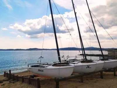 a sailboat sitting on the beach next to the water at Cannes Film Festival Beach Apartment in Cannes