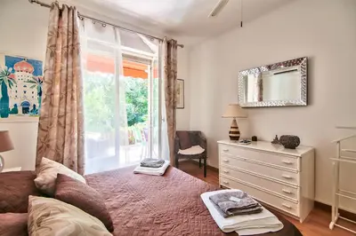 a bedroom with a bed and a dresser and a window at Cannes Film Festival Beach Apartment in Cannes