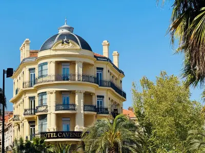 a bedroom with a white bed and a window at Le Cavendish in Cannes