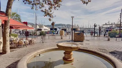a fountain in the middle of a street with a marina at Très Joli T3 Vieux Port Cannes in Cannes