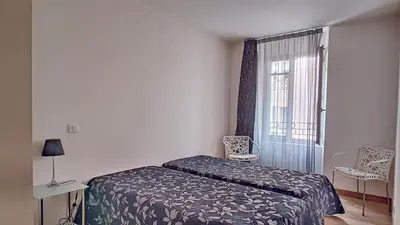 a small bedroom with a bed and a window at Très Joli T3 Vieux Port Cannes in Cannes