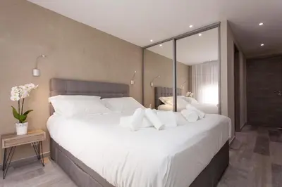 a bedroom with a large bed with white pillows at Palladium Palais des Festivals in Cannes