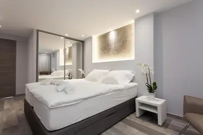 a bedroom with a large white bed and a mirror at Palladium Palais des Festivals in Cannes