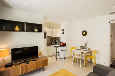 a living room with a television and a table with chairs at Le Petit Magellan in Cannes