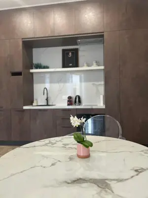 a kitchen with a table with a vase of flowers at Touchlux apartments in Cannes