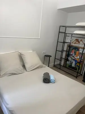 a white bed with two hats on top of it at Touchlux apartments in Cannes
