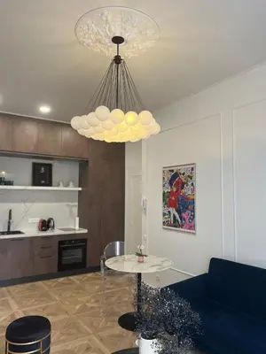 a living room with a table and a chandelier at Touchlux apartments in Cannes
