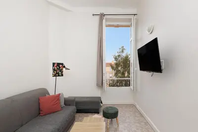 a white bedroom with two beds and a door at IMMOGROOM - Center - Modern - 10 min from Palais des Festivals in Cannes