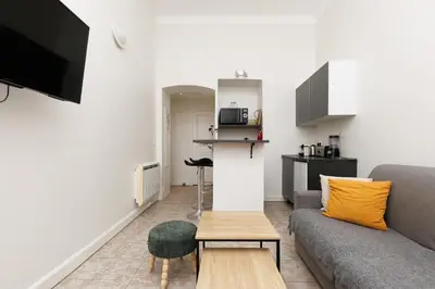 a bed in a bedroom with a white wall at IMMOGROOM - Center - Modern - 10 min from Palais des Festivals in Cannes