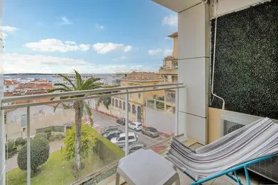 a balcony with a chair and a view of a street at IMMOGROOM - Sea view - Swimming Pool - Terrace- Clim in Cannes